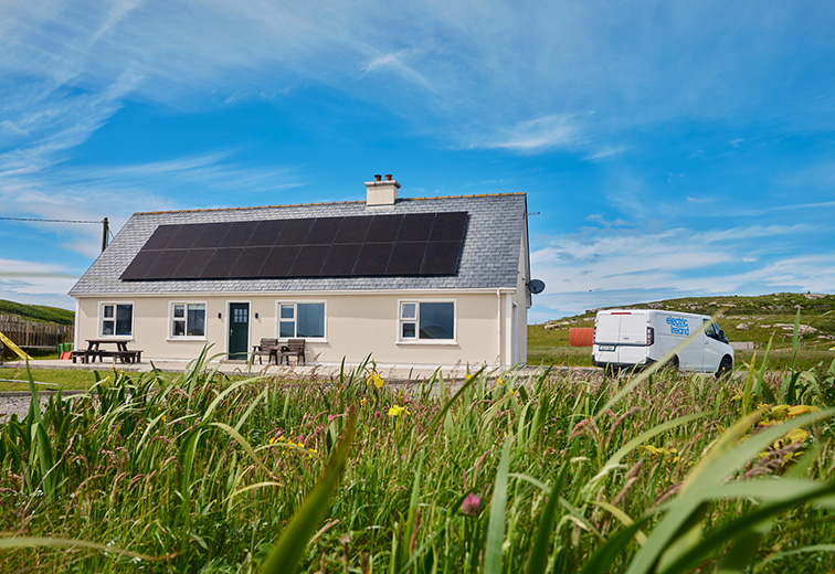 Solar panels on a house in Carrickfinn with an electric Ireland van outside