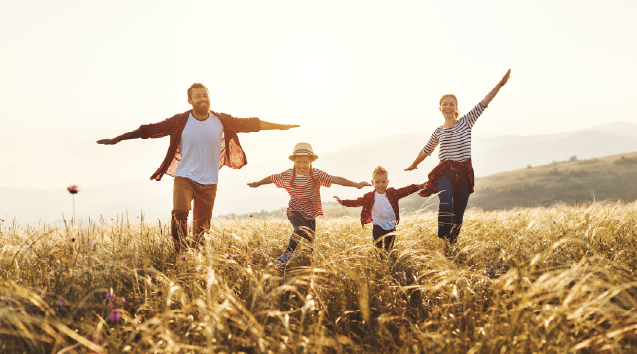 family of four running through wheat feild