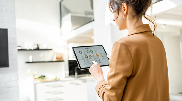 Female managing utilities on smart tablet in kitchen