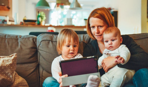 woman with her two children on tablet