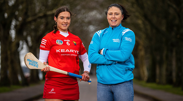 hurling player standing next to female in Electric Ireland sports gear 