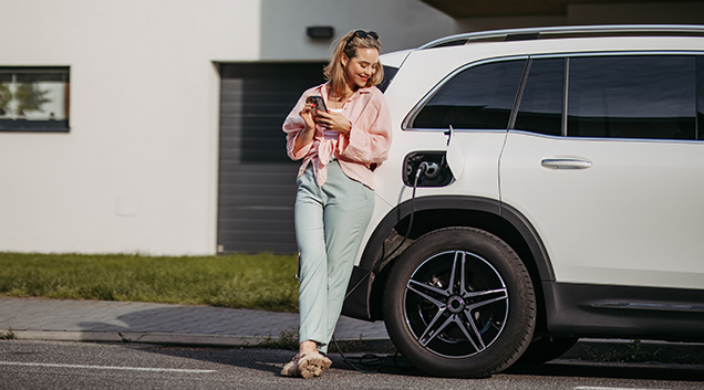 Woman leaning on ev while charging